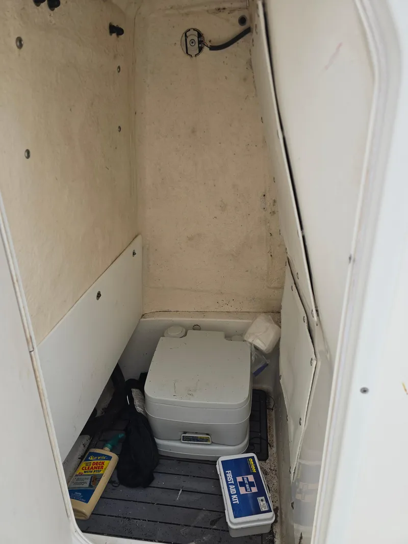 Slide: The Image of 2017 NauticStar 231 Coastal boat interior with portable toilet and storage items. - 14