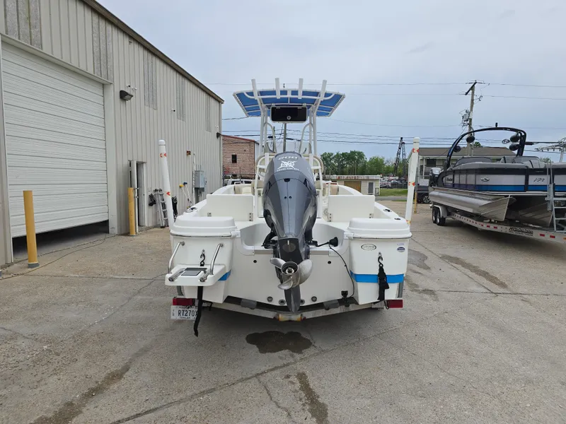 Slide: The Image of 2017 NauticStar 231 Coastal boat with outboard motor, parked near a warehouse. - 3