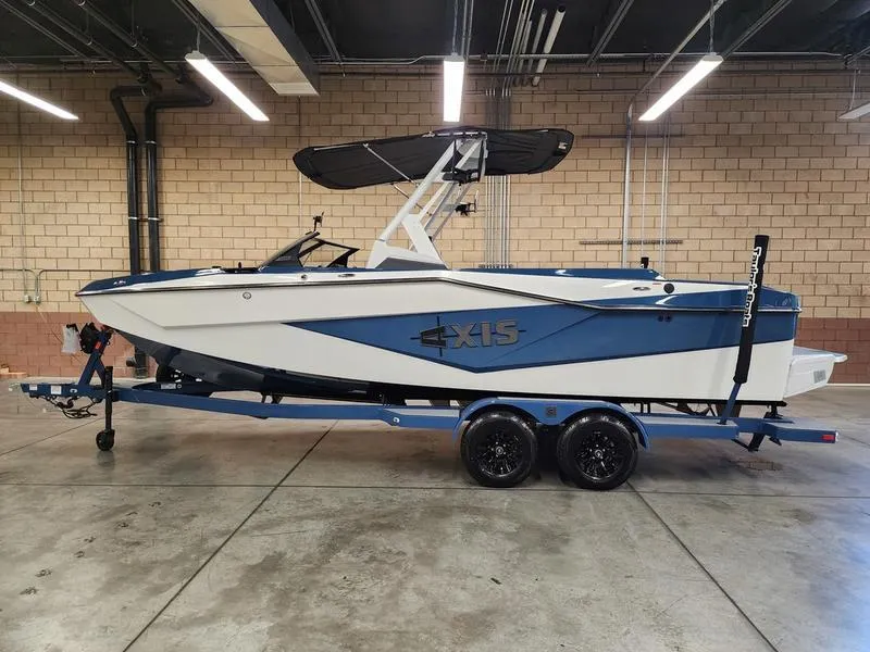 Slide: The Image of 2025 Axis T235 boat on trailer in indoor garage setting. - 1