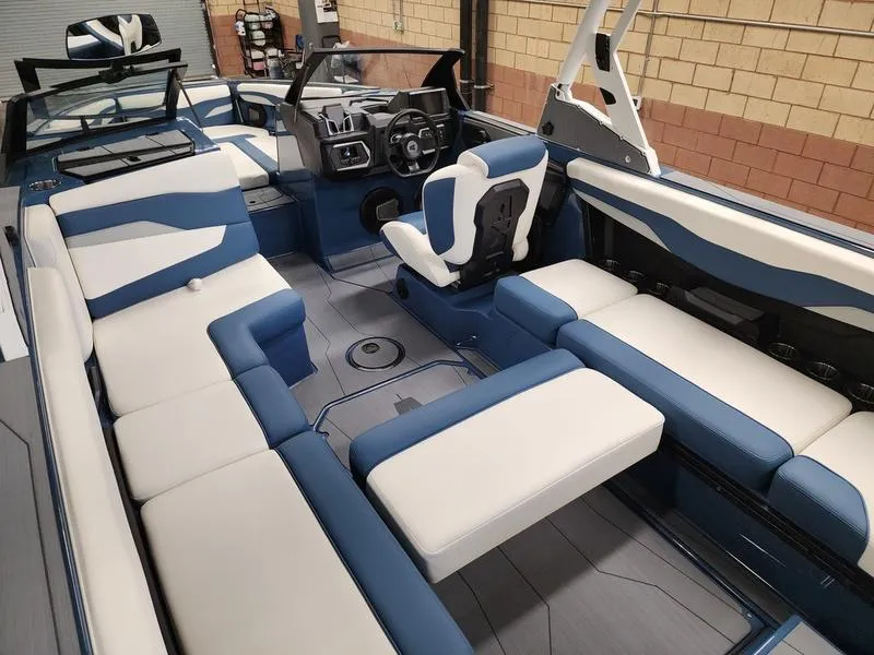 Slide: The Image of 2025 Axis T235 boat interior with blue and white seating, modern dashboard, and spacious layout. - 19