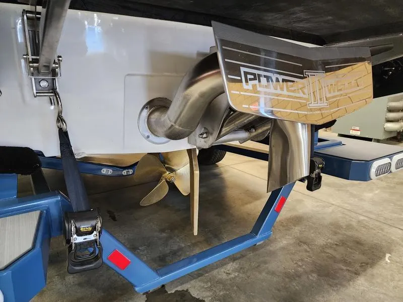 Slide: The Image of 2025 Axis T235 boat with propeller and exhaust system in a garage setting. - 9