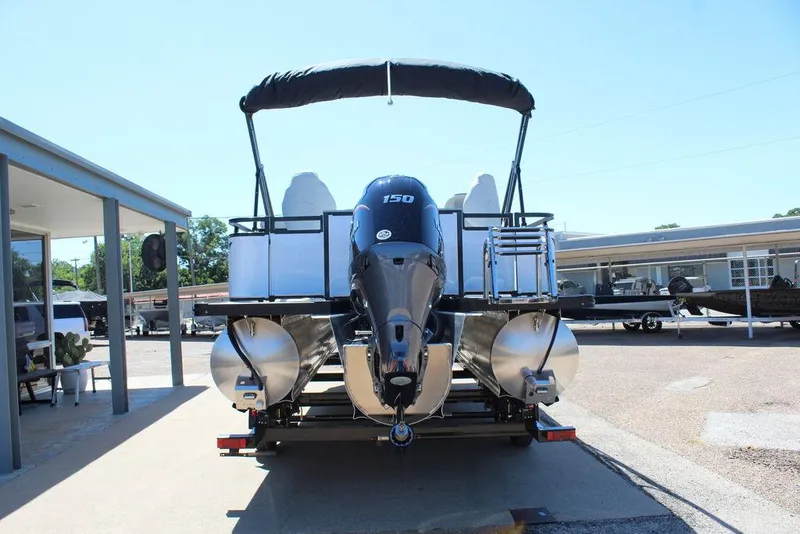 Slide: The Image of 2025 Avalon Venture 85 Rear Fish 23 FT pontoon boat with outboard motor, parked outdoors. - 3