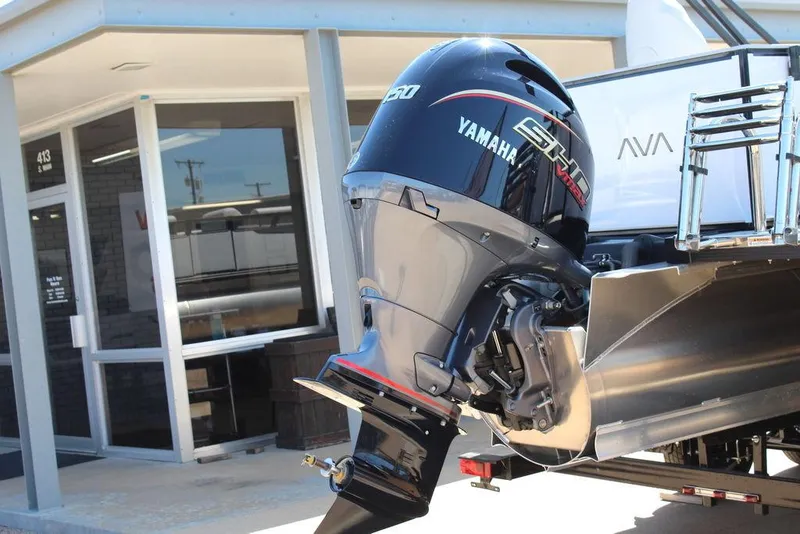 Slide: The Image of 2025 Avalon Venture 85 Rear Fish boat with Yamaha engine, parked outside a building. - 6