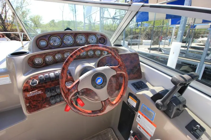 Slide: The Image of 2004 Four Winns 288 Vista boat dashboard with wood-trimmed steering wheel and control panel. - 14