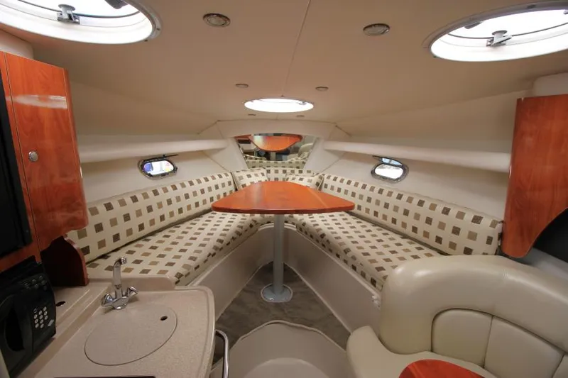 Slide: The Image of 2004 Four Winns 288 Vista cabin interior with seating, table, and portholes. - 19