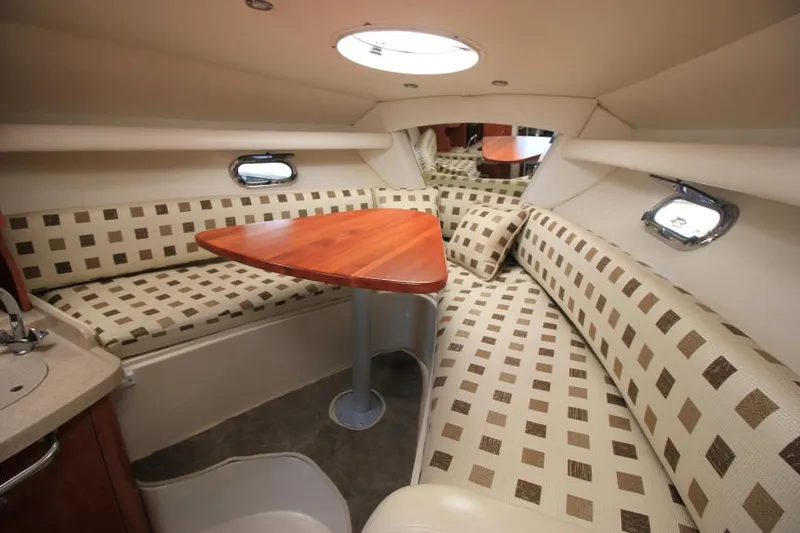 Slide: The Image of 2004 Four Winns 288 Vista cabin interior with patterned seating and wooden table. - 20