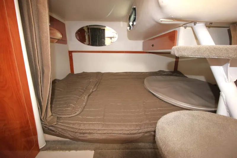 Slide: The Image of 2004 Four Winns 288 Vista cabin interior with bed, mirror, and storage. - 25