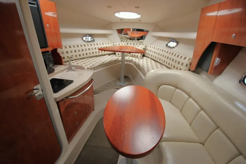 Slide: The Image of 2004 Four Winns 288 Vista cabin interior with seating, kitchenette, and wood accents. - 27