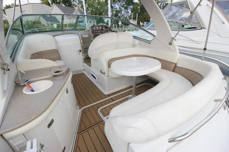 Slide: The Image of 2004 Four Winns 288 Vista boat interior with white seating, table, and kitchenette. - 29