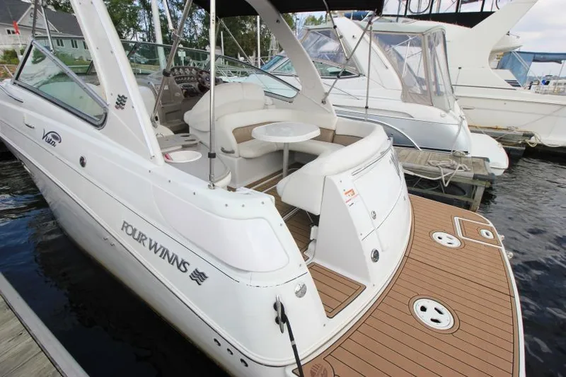 Slide: The Image of 2004 Four Winns 288 Vista boat docked, featuring spacious seating and elegant design. - 36