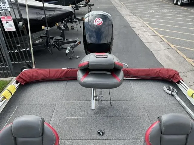 Slide: The Image of 2020 Ranger RT198P boat interior with seating and motor, parked in a lot. - 9