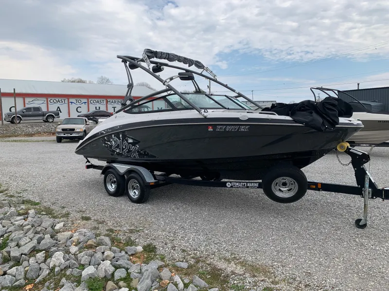 Slide: The Image of 2014 Yamaha Boats 212X on trailer, parked outdoors, with overcast sky. - 0