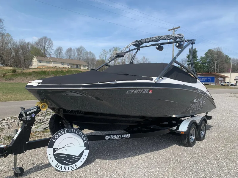 Slide: The Image of 2014 Yamaha Boats 212X on trailer, parked outdoors, with Coast to Coast Marine branding. - 2