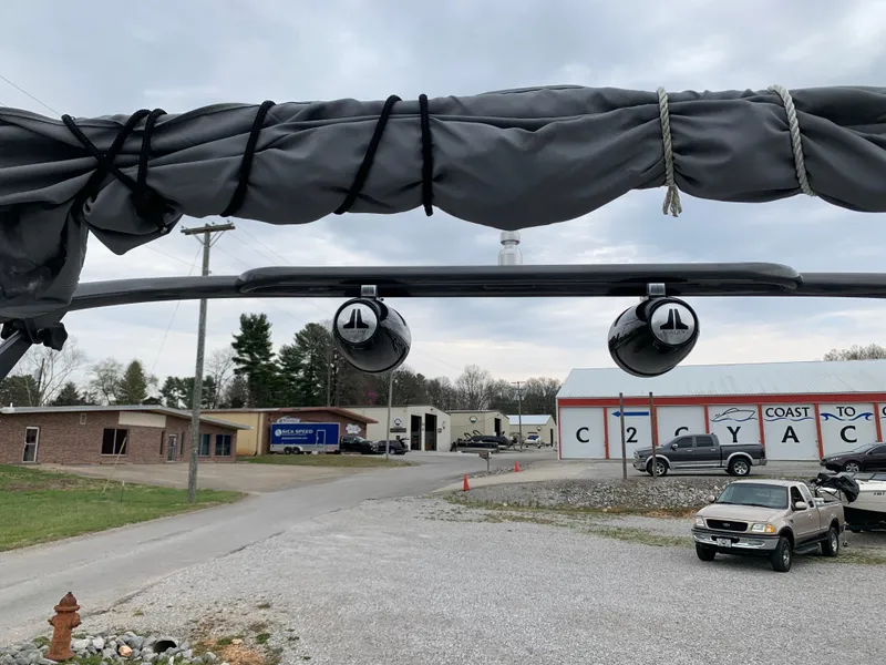 Slide: The Image of 2014 Yamaha Boats 212X with covered equipment, parked in a lot with vehicles and buildings. - 9