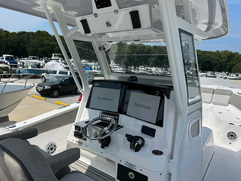 Slide: The Image of 2024 Sea Fox 328 Commander boat cockpit with Garmin navigation displays at a marina. - 8