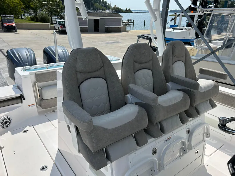 Slide: The Image of 2024 Sea Fox 328 Commander boat with three cushioned seats and dual outboard motors. - 9