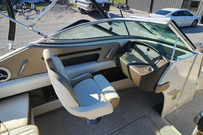 Slide: The Image of 2007 Sea Ray 210 Select boat interior with beige seating and sleek dashboard design. - 11