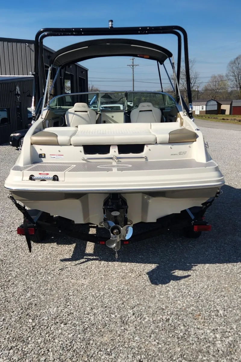 Slide: The Image of 2007 Sea Ray 210 Select boat, rear view, parked on gravel, with bimini top. - 4