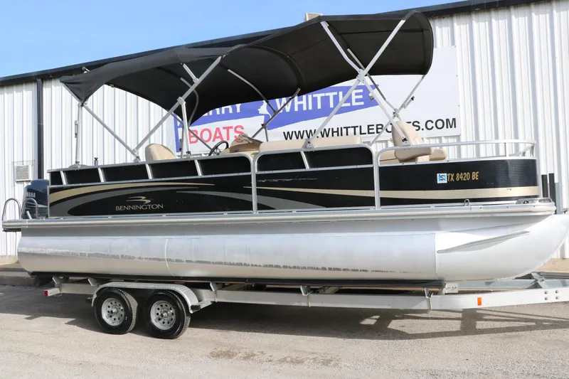 Slide: The Image of 2010 Bennington 2275 GLI pontoon boat on trailer, parked outside dealership. - 1