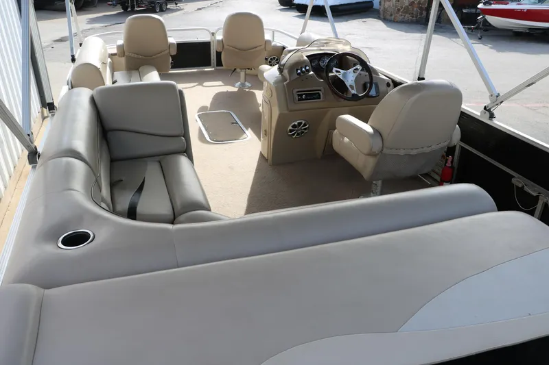 Slide: The Image of 2010 Bennington 2275 GLI pontoon boat interior with beige seating and steering console. - 19