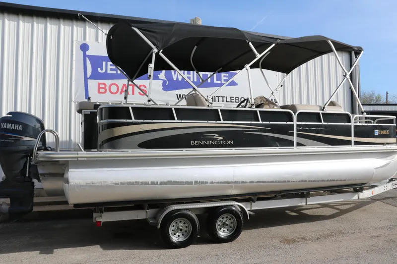 Slide: The Image of 2010 Bennington 2275 GLI pontoon boat on trailer, parked outside dealership. - 2