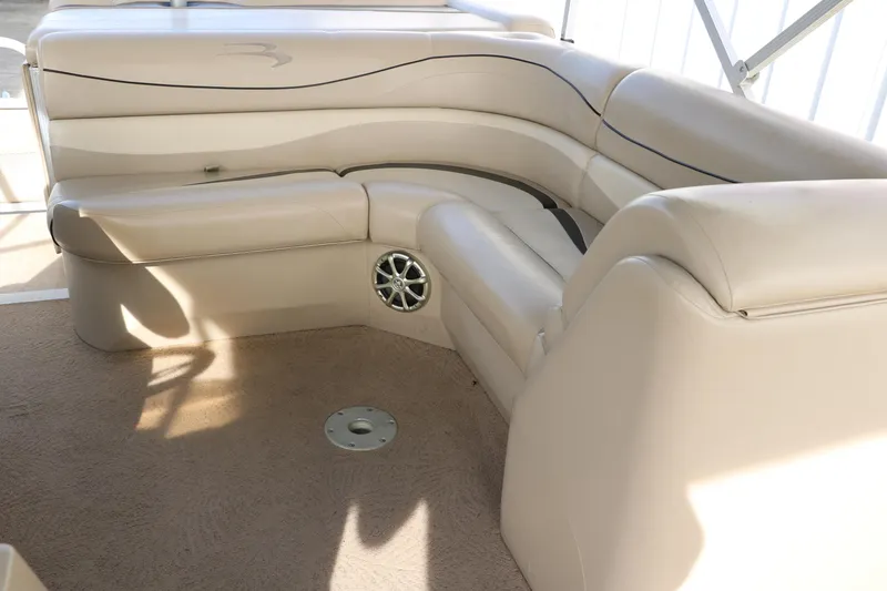 Slide: The Image of 2010 Bennington 2275 GLI boat interior with beige seating and speaker. - 30