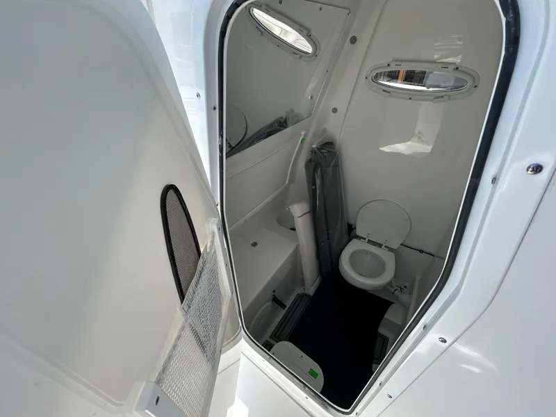 Slide: The Image of Interior view of 2025 Sea Hunt Gamefish 28 boat bathroom with toilet and portholes. - 15