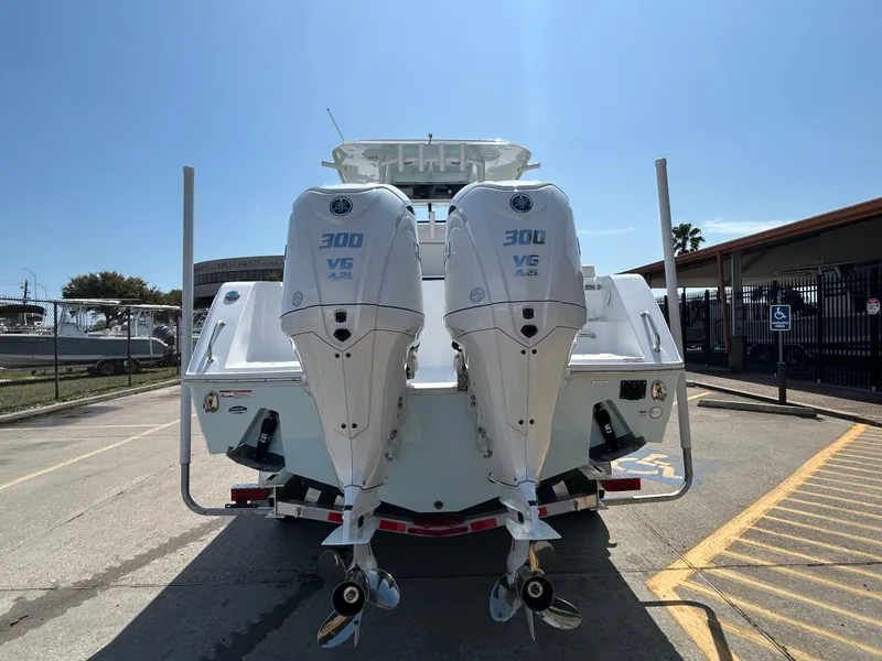 Slide: The Image of 2025 Sea Hunt Gamefish 28 with twin 300 V6 engines, rear view in a parking lot. - 5