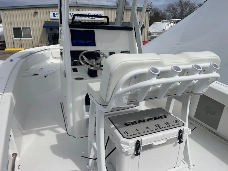 Slide: The Image of 2025 Sea Pro 242 Center Console boat interior with helm, seating, and rod holders. - 12