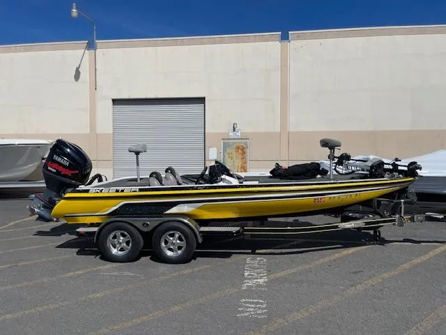 Slide: The Image of 2006 Skeeter 20i yellow fishing boat on trailer, parked outdoors. - 0