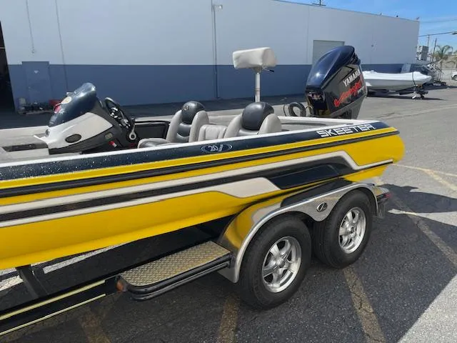 Slide: The Image of 2006 Skeeter 20i boat with Yamaha engine, yellow and black design, parked on a trailer. - 2