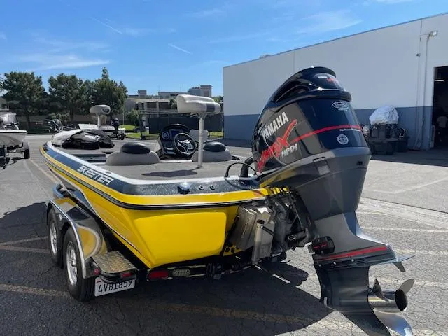Slide: The Image of 2006 Skeeter 20i boat with Yamaha engine, parked outdoors on a sunny day. - 4