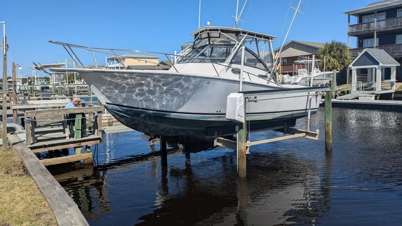 Slide: The Image of 1996 Albemarle 275 Express boat docked at a marina, elevated above water. - 0
