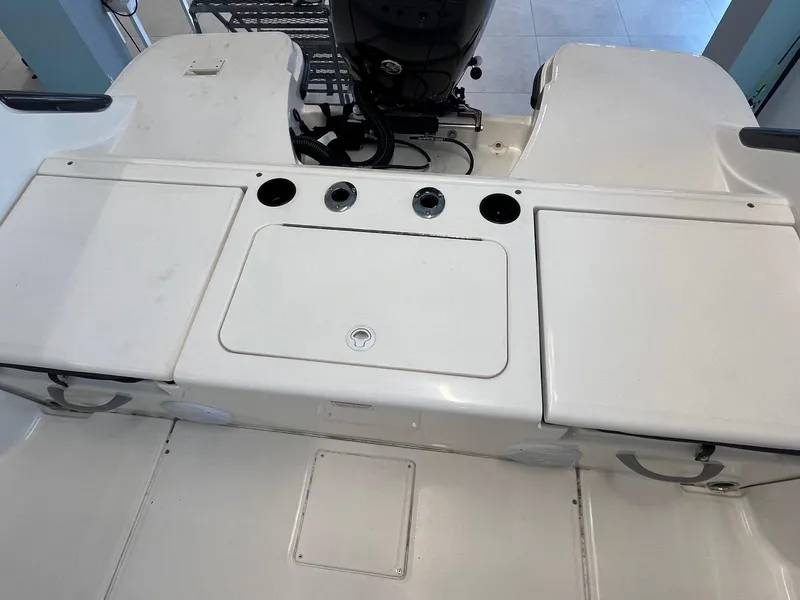 Slide: The Image of 2022 Bayliner Trophy T22CC boat deck with storage compartments and motor. - 11