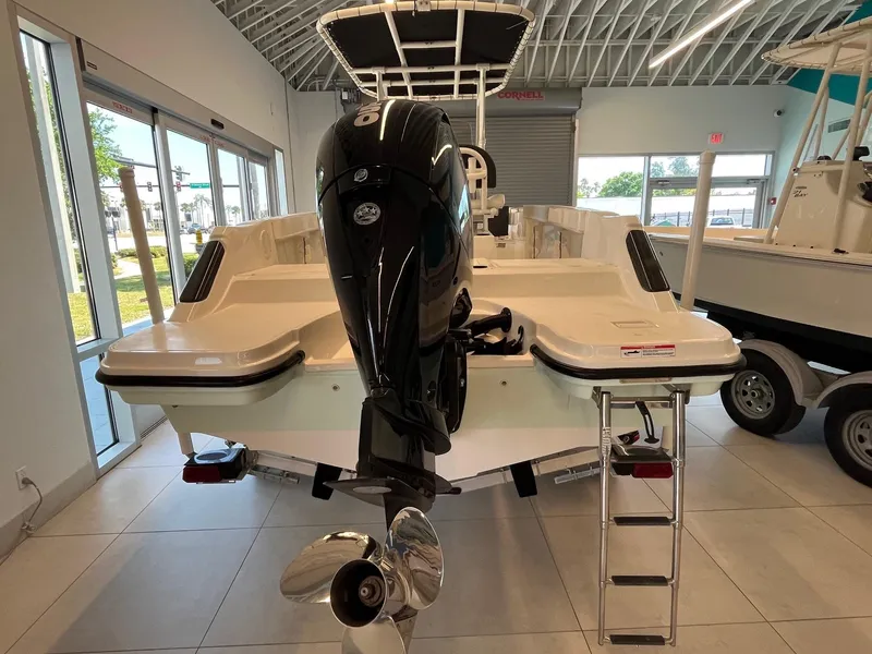 Slide: The Image of 2022 Bayliner Trophy T22CC boat with outboard motor and ladder in showroom. - 4