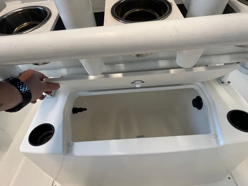 Slide: The Image of 2022 Bayliner Trophy T22CC boat storage compartment with cup holders and hand opening lid. - 9