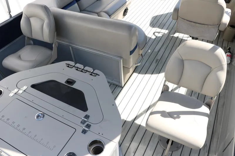 Slide: The Image of 2017 Berkshire 211RFC CTS boat interior with beige seating and table on wooden deck. - 23