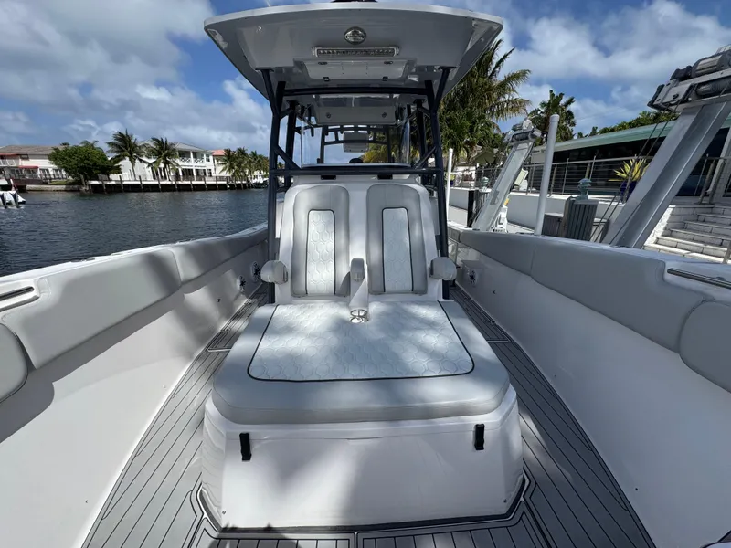 Slide: The Image of 2023 Sea Fox 328 Commander boat interior with seating, docked by waterfront homes. - 13
