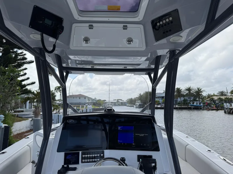 Slide: The Image of 2023 Sea Fox 328 Commander boat cockpit with advanced navigation systems, docked by a scenic canal. - 17