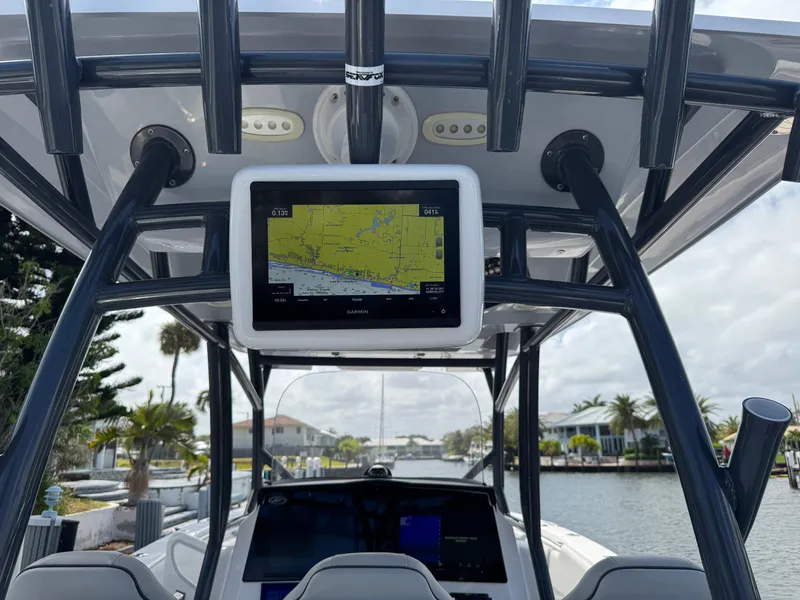 Slide: The Image of 2023 Sea Fox 328 Commander boat with navigation screen, docked in a scenic canal. - 18
