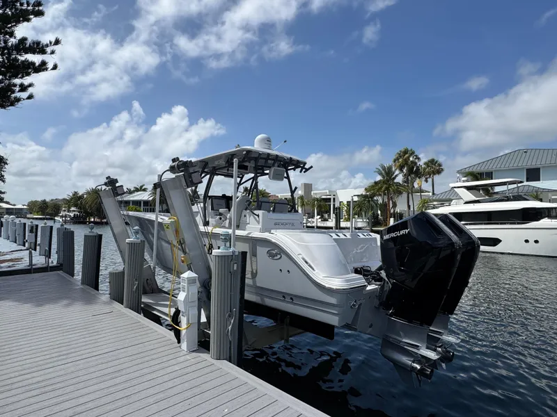 Slide: The Image of 2023 Sea Fox 328 Commander boat docked, featuring dual Mercury engines, under a clear blue sky. - 2