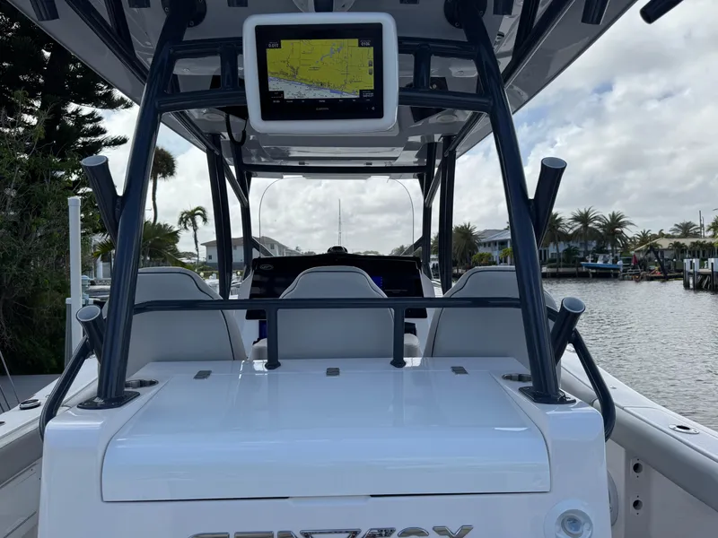 Slide: The Image of 2023 Sea Fox 328 Commander boat with navigation screen, docked near palm trees and waterfront homes. - 22