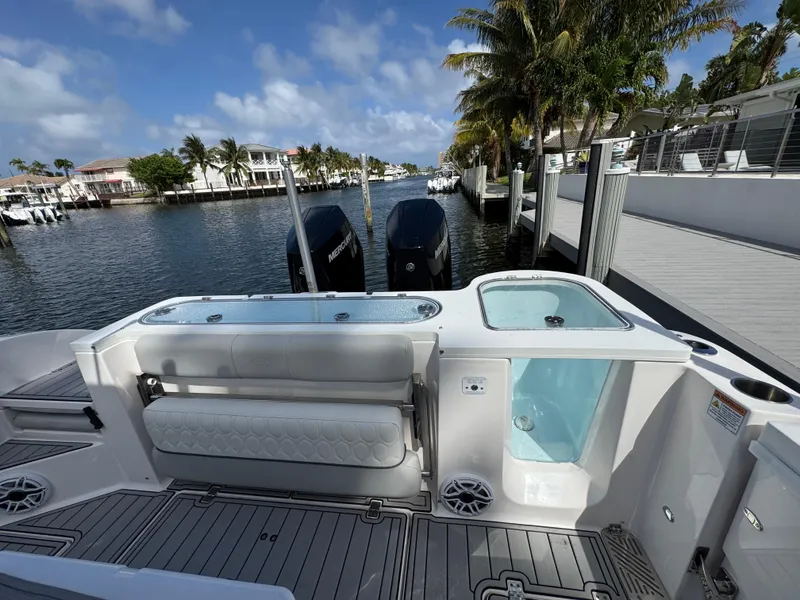 Slide: The Image of 2023 Sea Fox 328 Commander boat docked by a scenic waterfront with palm trees. - 28
