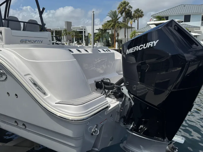 Slide: The Image of 2023 Sea Fox 328 Commander boat with Mercury engine, docked near palm trees. - 6