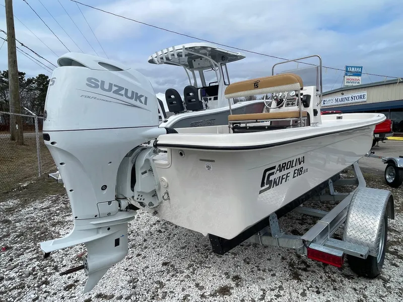 Slide: The Image of 2025 Carolina Skiff E18 JVX CC boat with Suzuki outboard motor on trailer. - 3