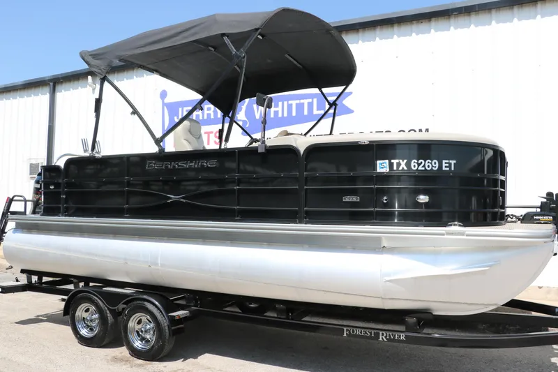 Slide: The Image of 2019 Berkshire 211RFC CTS pontoon boat on trailer, black canopy, parked outside. - 13