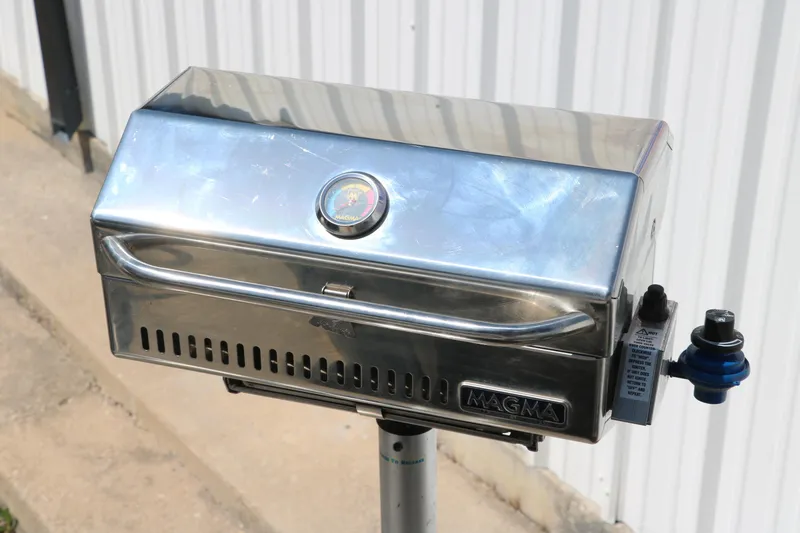Slide: The Image of Stainless steel Magma grill mounted outdoors, featuring a temperature gauge. - 35