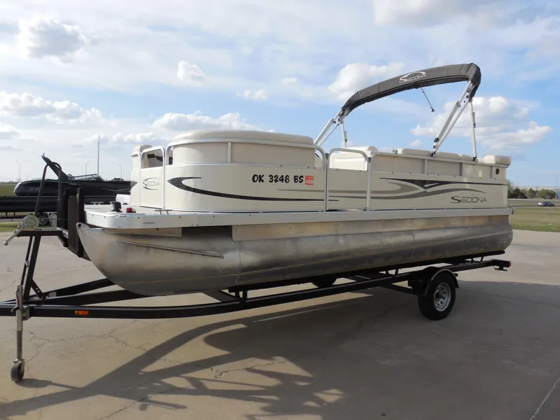 Slide: The Image of 2007 Bennington 21L Sedona pontoon boat on trailer, parked outdoors under cloudy sky. - 6