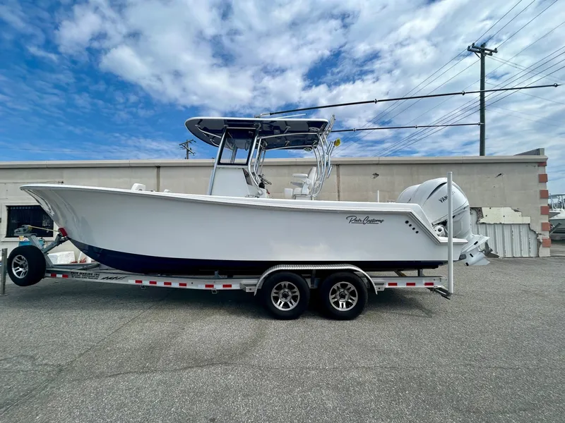 The Image of 2025 Pair Customs 28 Center Console boat on trailer, parked outdoors under cloudy sky. - 1