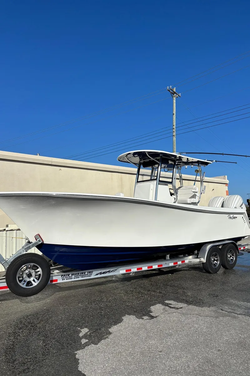 Slide: The Image of 2025 Pair Customs 28 Center Console boat on trailer, clear blue sky background. - 11